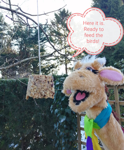 Harold the giraffe is in the garden having hung up his bird feeder which is now ready.