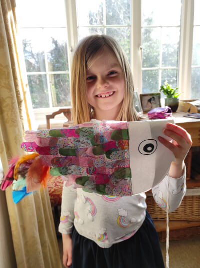 Photo of child with paper kite made  by her.
